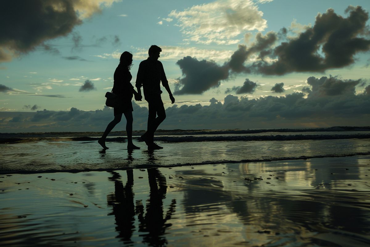 Silhouettes of the main characters walking hand in hand along the beach.